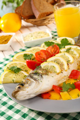 Delicious grilled fish on plate on table close-up