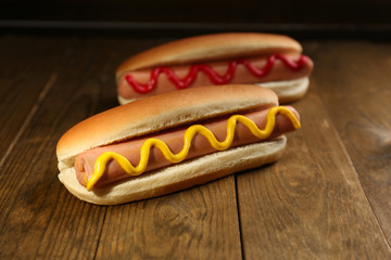 Tasty hot dogs on wooden table