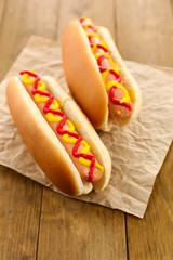 Tasty hot dogs on wooden table