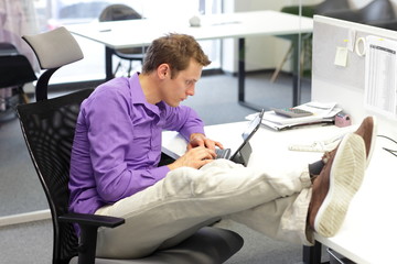 businessman in office working with tablet - bad sitting posture