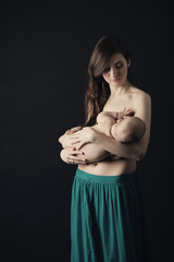 Mother breast feeding her infant studio shot