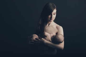 Mother breast feeding her infant studio shot
