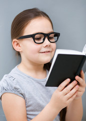 Little girl is reading a book