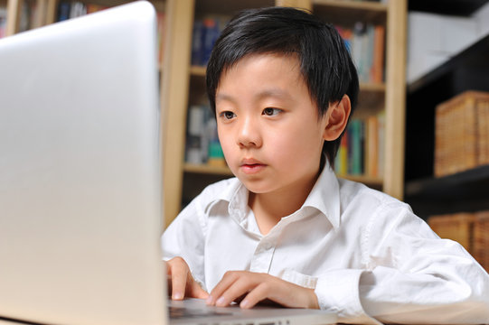 Closeup of young boy working on computer