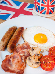 Bacon and eggs with cup of tea and british flag behind