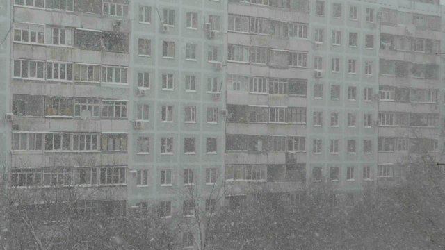 Снегопад на фоне многоквартирного дома