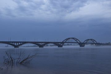 Fototapeta na wymiar Bridge over river in fog