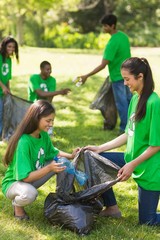 Team of volunteers picking up litter in park