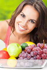 Woman with plate of fruits, outdoors