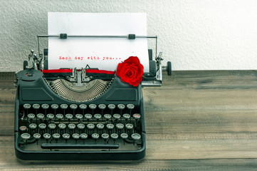 vintage typewriter with love letter and red rose flower