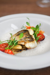 Close image of fish on dish with shrimps in restaurant