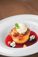 Image of tasty dessert with icecream and strawberries syrup in r