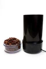 Cup with coffee beans electric grinder isolated