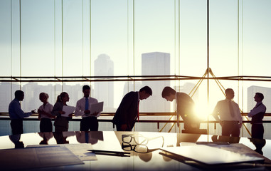 Group of business people and men bowing reflected onto table wit