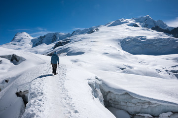 Trekker walking on snow with Mera Peak in background, Nepal