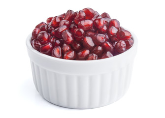 Fresh pomegranate seeds in white bowl, isolated on white
