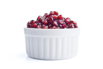 Fresh pomegranate seeds in white bowl, isolated on white
