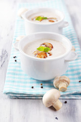 Mushroom soup in white pots, on napkin,  on wooden background
