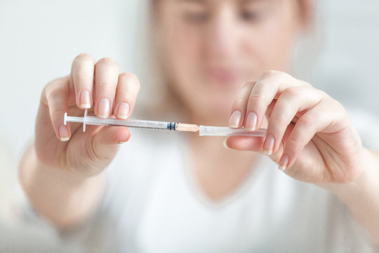 Closeup shot of woman holding small syringe