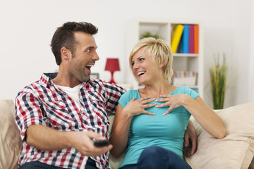 Laughing couple spending time at home with funny movie