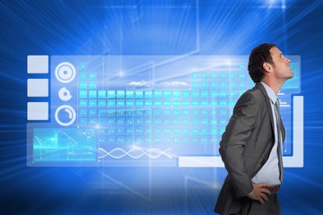 Composite image of smiling businessman with hands on hips