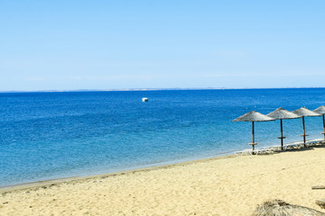 Beach chairs on sand beach and boats
