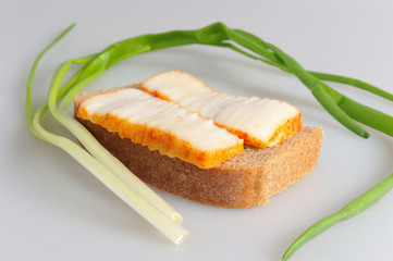 A sandwich with lard and green onion on gray