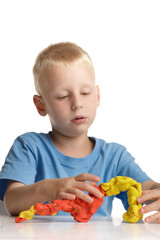 Little boy playing with modeling clay.