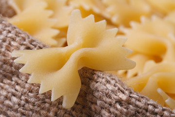 Farfalle pasta dry closeup on sackcloth. horizontal