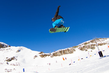 Snowboarder grabbing his snowboard
