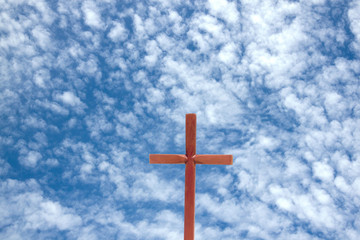 Wooden Cross Against Blue Cloudy Sky Background