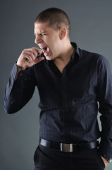 Angry businessman biting a mobile phon