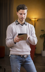 Handsome young man with tablet PC at home