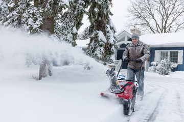 Man clearing driveway with snowblower