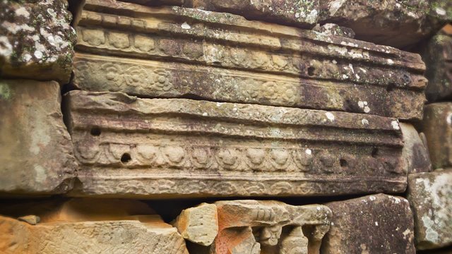 Stone blocks from the ancient wall of the temple. Angkor, Cambod