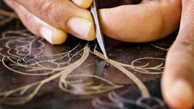 Patterning the surface of the varnish in the workshop. Burma, Ma
