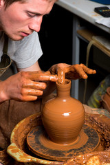 hands of a potter, creating an earthen jar
