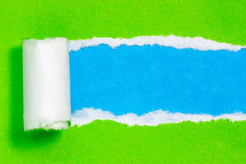 Torn green color paper on blue  background