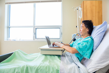 Patient Using Laptop On Hospital Bed