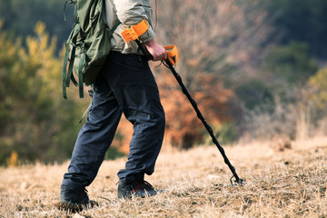 man searching in the field with metal detector, treasure hunt background 