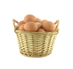 Chicken eggs in brown small handmade wicker basket isolated