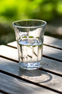 Glass of fresh water on a table outdoors.