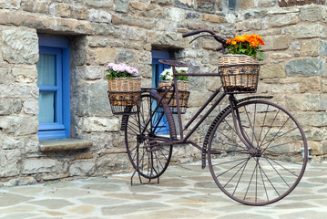 Fototapeta na wymiar Rusty bicycle in front of a traditional house in Epirus, Greece