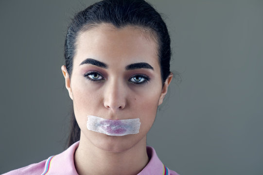 Young woman silenced with a masking tape