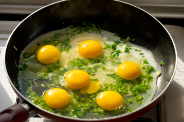 A freshly cooked eggs with herbs in a frying pan