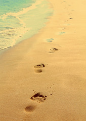 Fototapeta na wymiar footprints on beach - vintage retro style