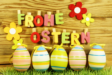 Frohe Ostern - Schriftzug mit Ostereiern auf Brett