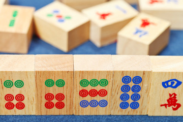 wood tiles closeup in mahjong game on blue cloth