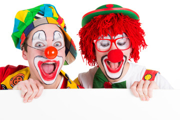 clowns schauen begeistert auf schild