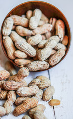 Roasted peanuts on white wooden background